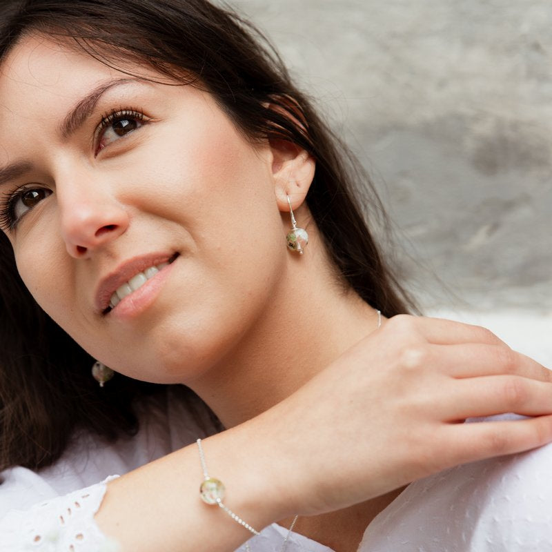 Boucles d'oreilles et bracelet en perles de verre artisanaux portés sur femme