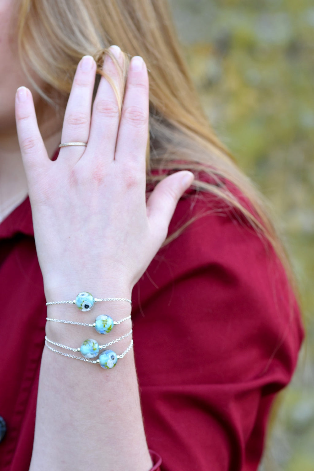Bracelets en perles de verre artisanaux portés sur poignée de femme