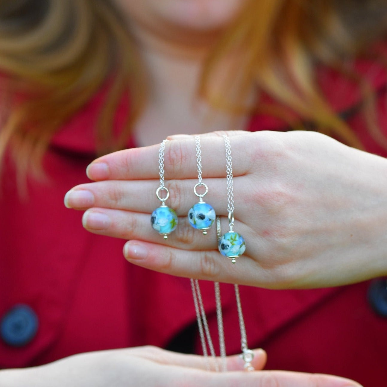 Pendentifs en perles de verre artisanaux sur main de femme