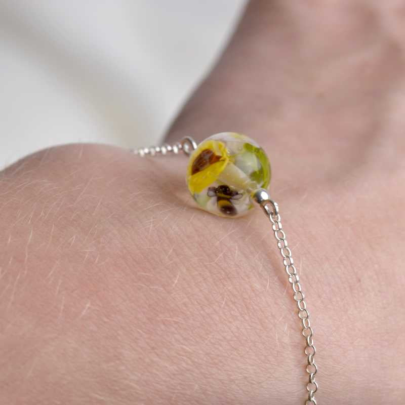 Bracelet en perles de verre artisanal porté sur poignée de femme