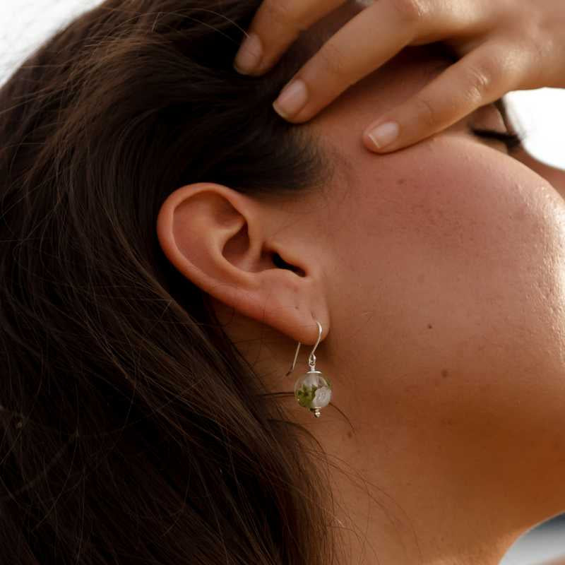 Boucle d'oreille en perles de verre artisanale sur oreille de femme