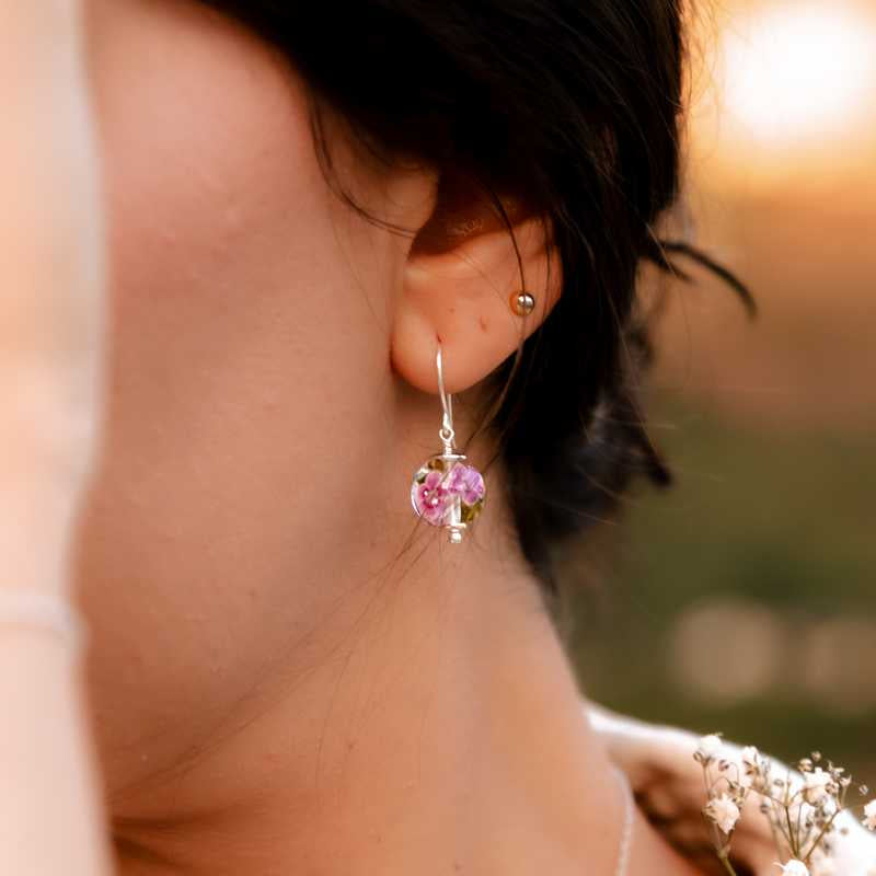 Boucle d'oreille en perles de verre artisanale sur oreille de femme