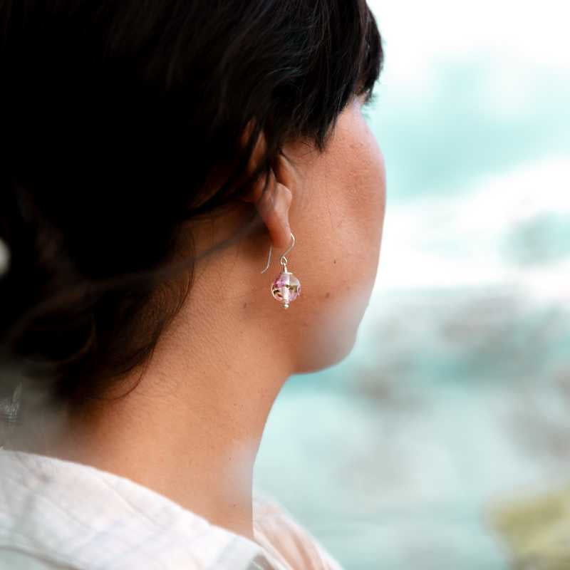 Boucle d'oreille en perles de verre artisanale sur oreille de femme